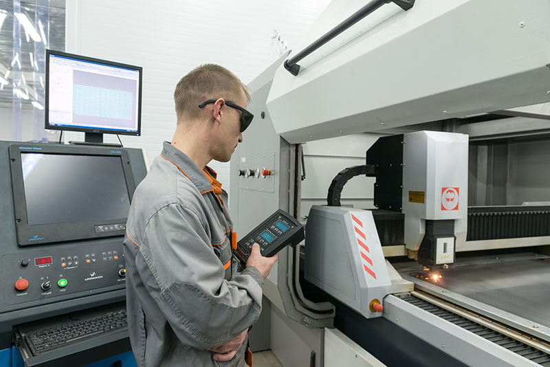 Hombre revisando el trabajo de una máquina con implementos de seguridad